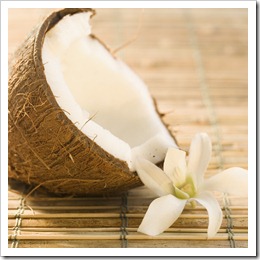 Half Coconut and Flower on Bamboo Mat --- Image by © Royalty-Free/Corbis